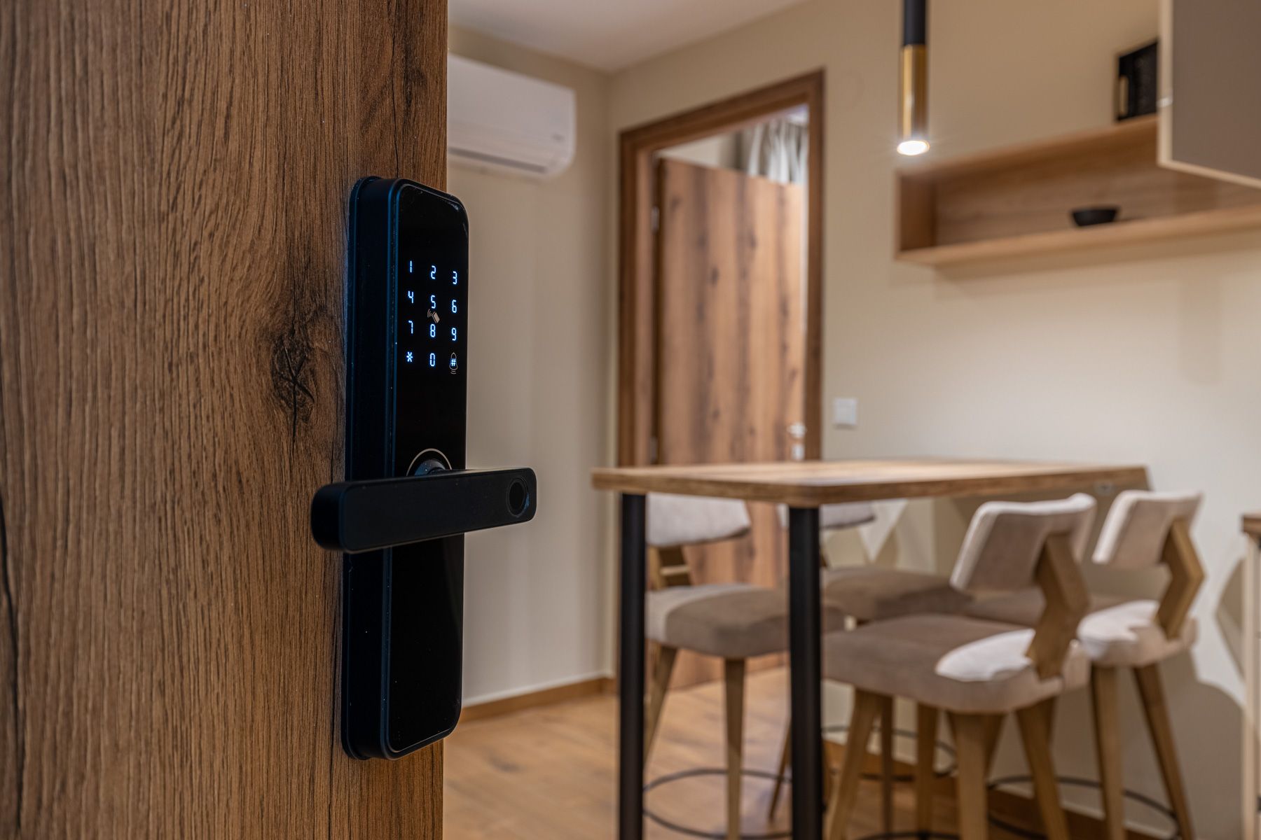 The keypad lock on Anemoessa's oak door, with the dining table beyond