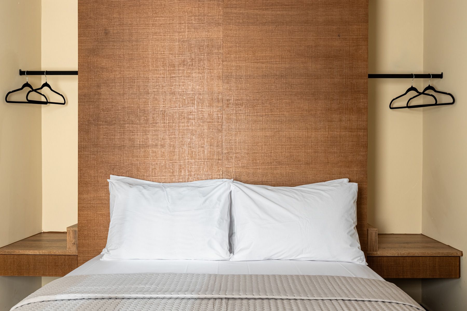 The double bed in Asteroessa, made up in Coco-Mat linen against a grasscloth headboard