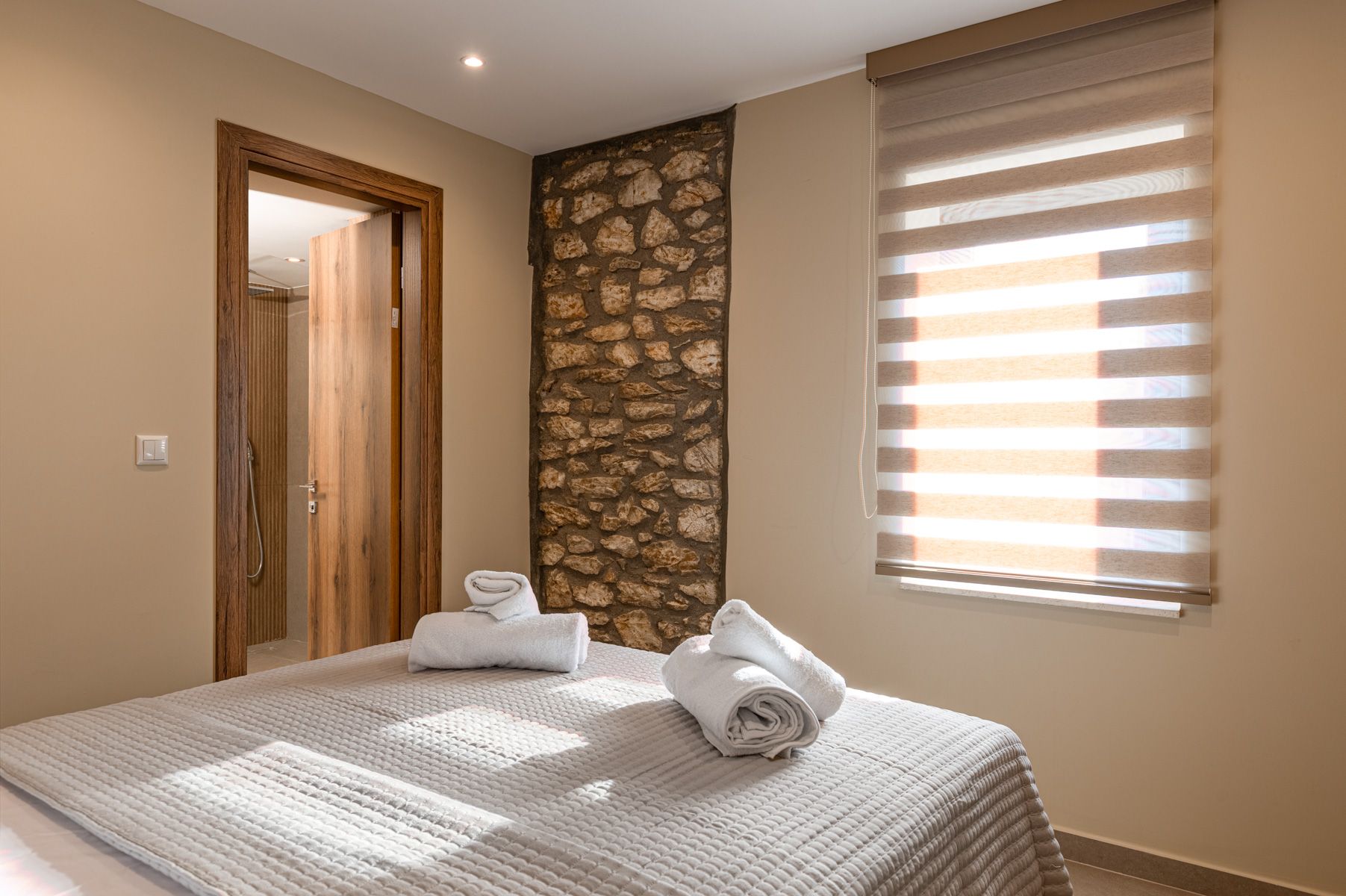 A column of the house's original stone beside the bed in Asteroessa