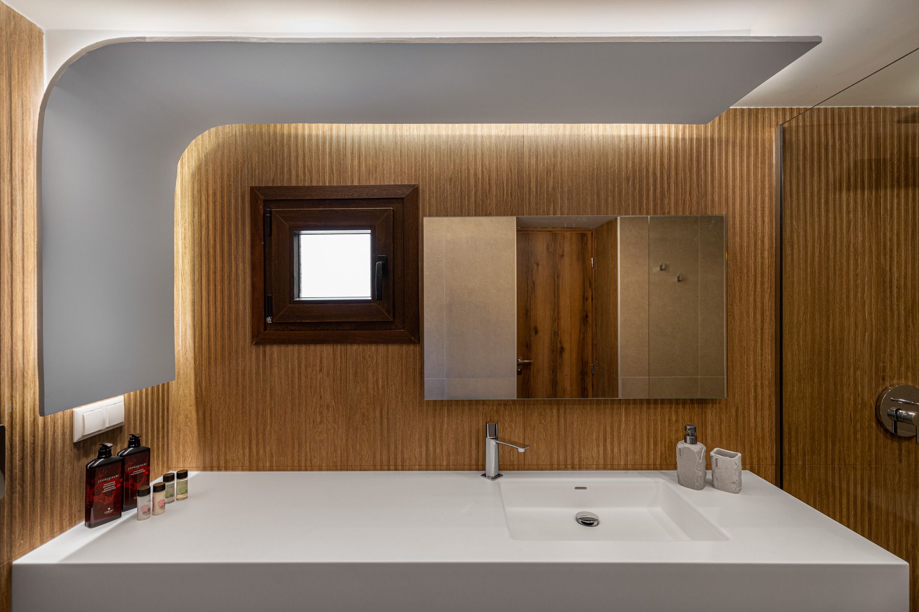 The long stone basin in Asteroessa's bathroom, under a backlit mirror
