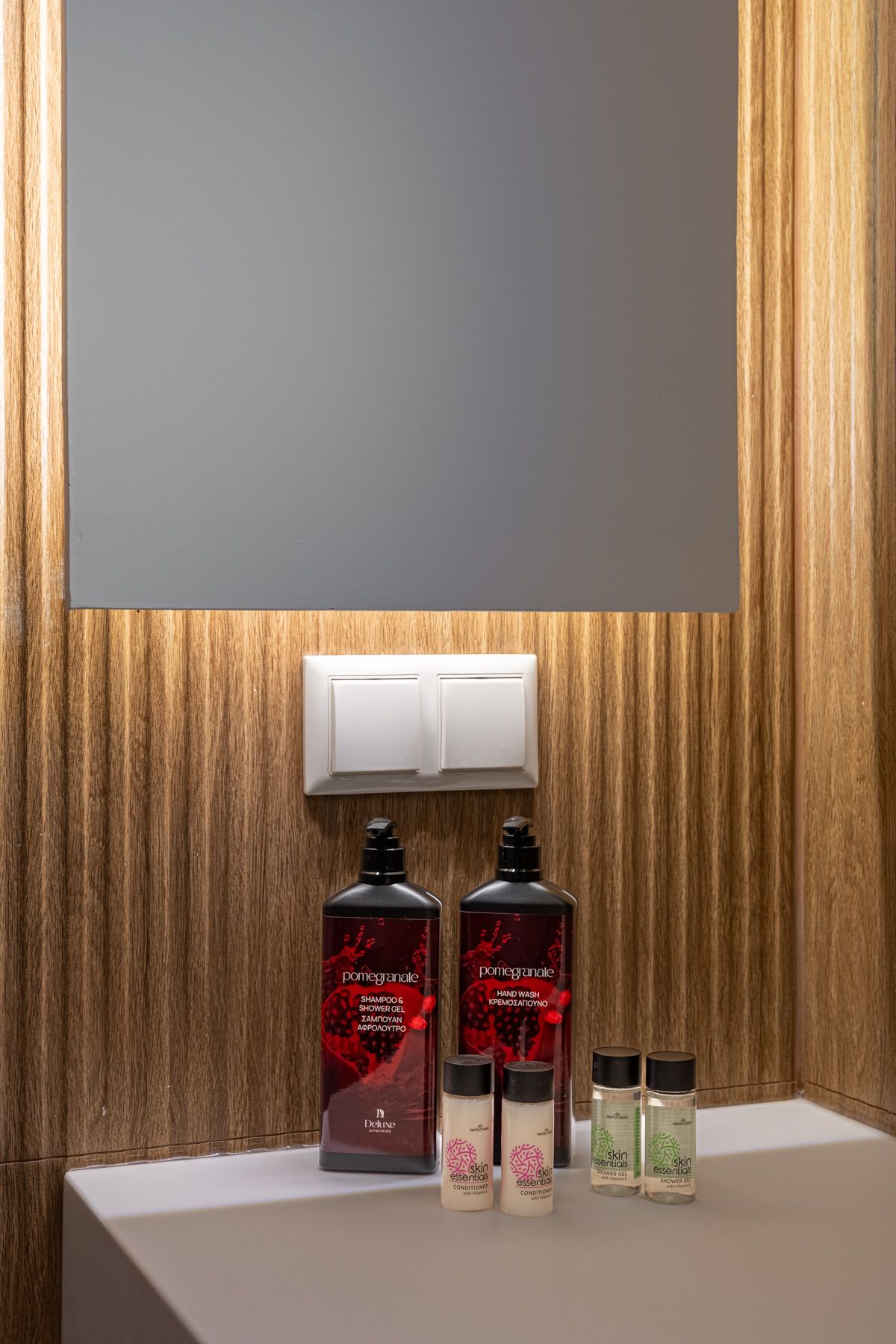 Bath products on the counter in Asteroessa, under the backlit mirror