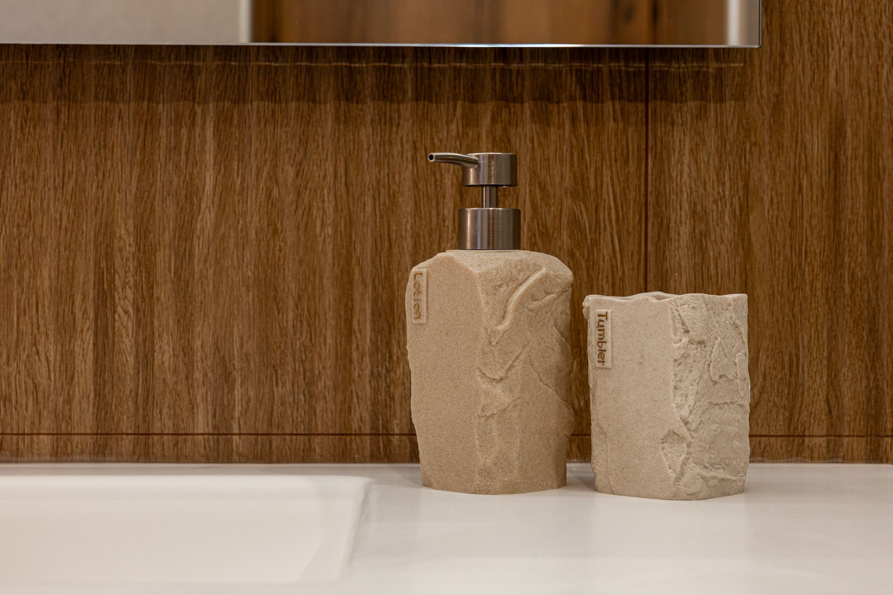 Stone soap dispenser and tumbler on Asteroessa's basin