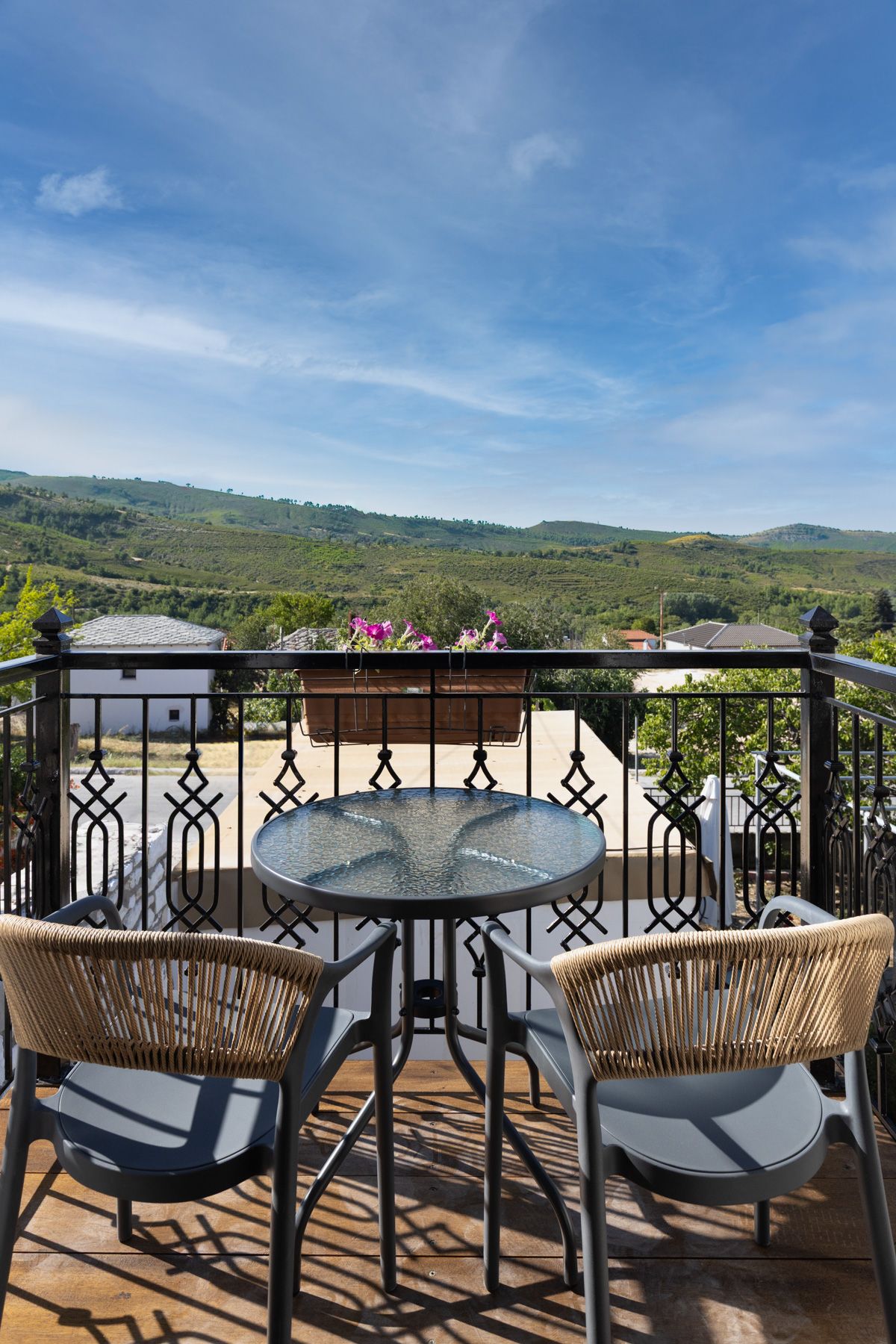 Two chairs and a table on Asteroessa's private balcony, above the valley