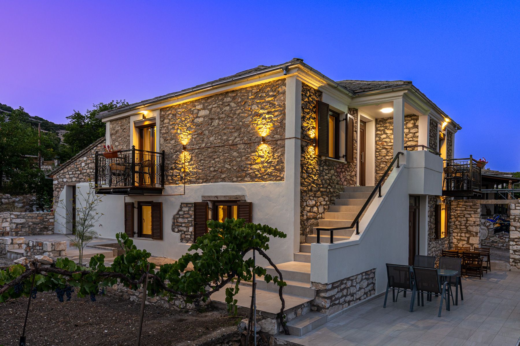 The house lit at dusk against a violet sky
