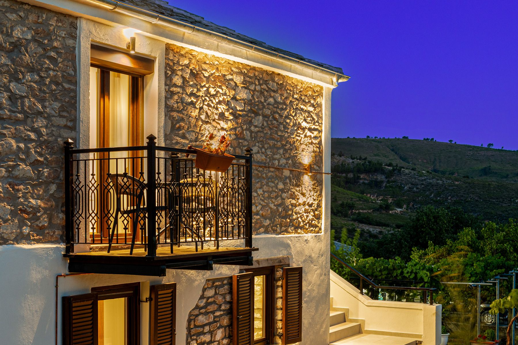 The stone facade and balcony under warm light at night